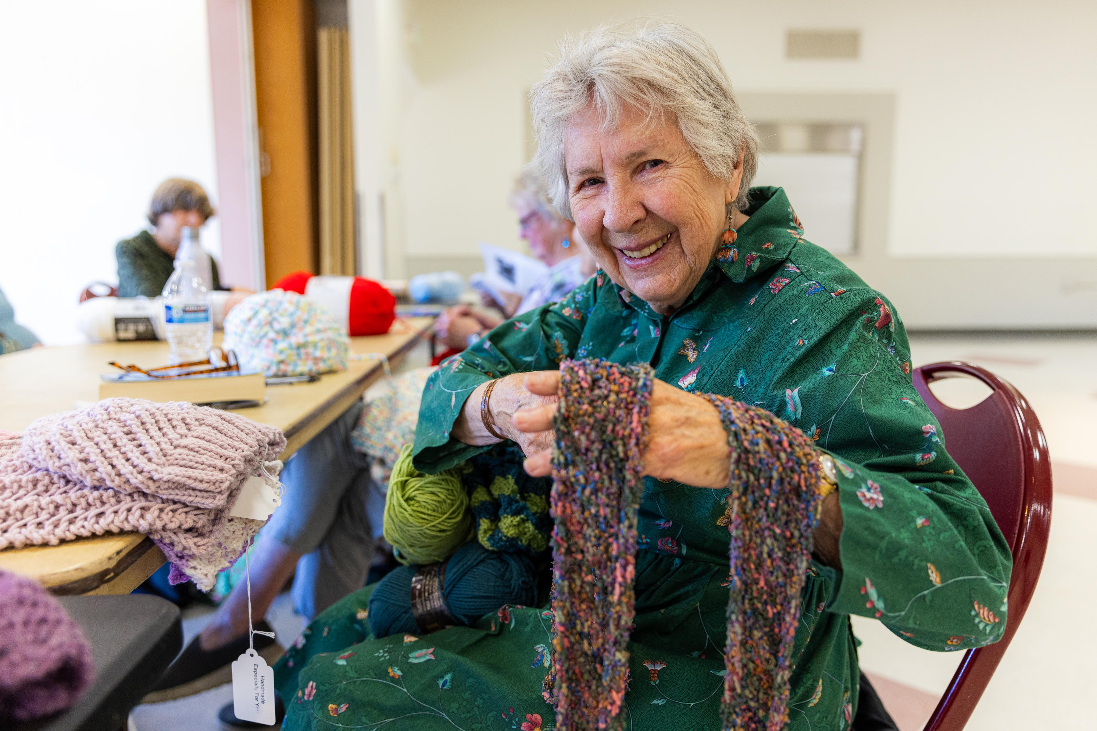 Knitting Club member shows off a scarf they made