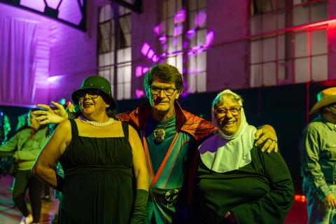Three participants dressed in their Halloween Costumes smiling at the camera
