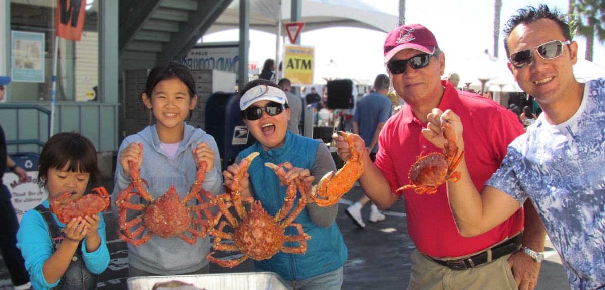 Family holds up crabs at the Santa Barbara Harbor and Sea Food Festival!