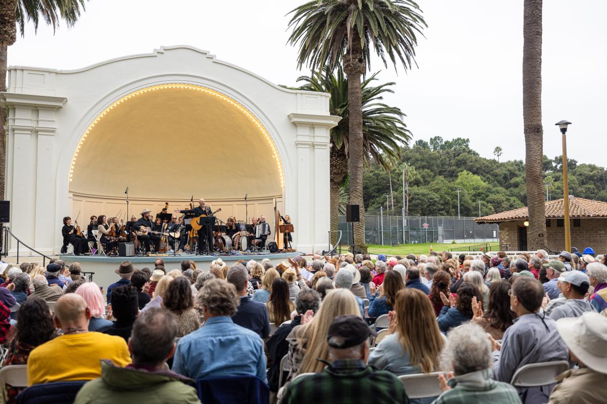 Folk Orchestra performing at the Plaza Del Mar Band Shell in front of a large crowd