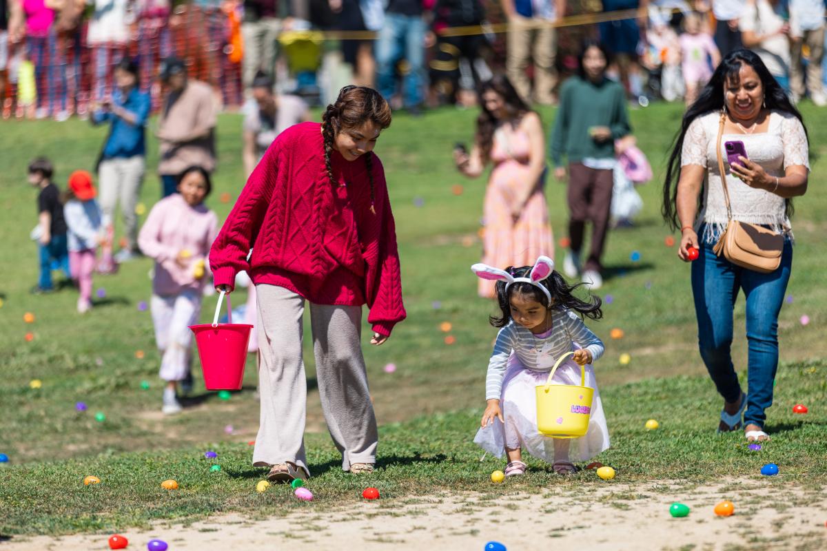 Children on grass picking up plastic eggs